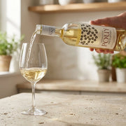 2023 Pouy - Cotes de Gascogne (750ml) | Create an ultra-photorealistic commercial photograph featuring the uploaded 2023 Pouy - Cotes de Gascogne (750ml) bottle in the provided image as it pours wine