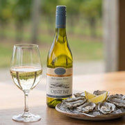 2025 Oyster Bay - Sauvignon Blanc Marlborough (750ml) | This wine with a plate of oysters. just show the bottle and wine glass on the table...